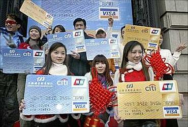Models show replicas of joint Shanghai Pudong Development Bank-Citigroup credit card during its launching in the financial hub of Shanghai.