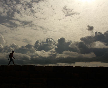 A boy walks along the seawall on the outskirts of the southern Indian city of Kochi