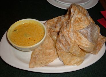 A steaming plate of Roti Canai with Curry Chicken Sauce