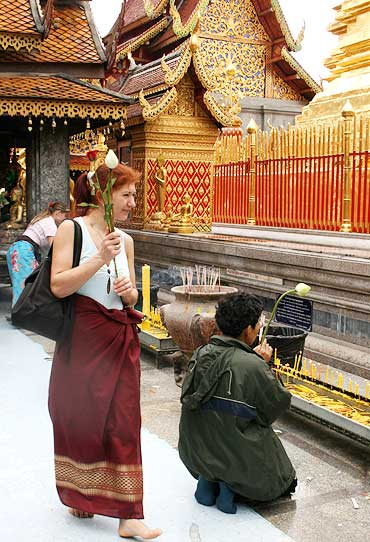 A visitor clasps offerings at the Wat Phrathat Doi Suthep temple.