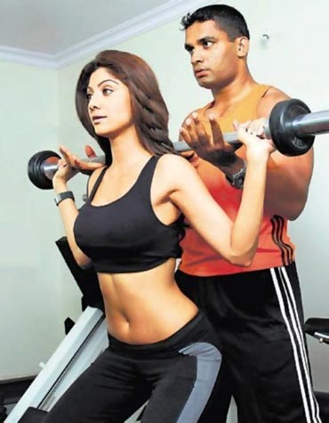 Shilpa Shetty being trained by a fitness instructor