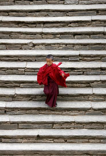 A monk runs down the steps of the Paro Dzong, a fortress.