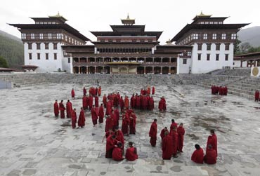 Buddhist monks stand inside the complex of Tashichho Dzong in Thimphu.