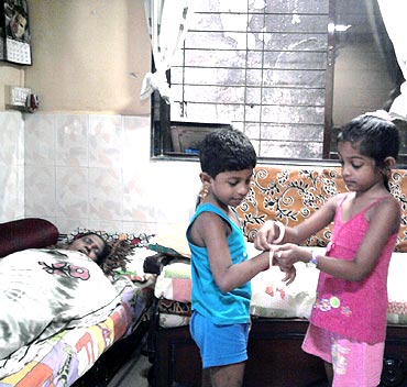 Rachael Bhandoo ties a rakhi to her brother Reece