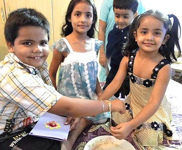 Menka Relhan's son (left) is tied a rakhi by his sister (right)