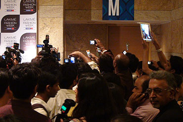 The media and regular attendees scramble to take pictures of the celebrities as they enter the venue