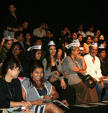 Supporters wearing Anna caps watch a showing at Lakme Fashion Week