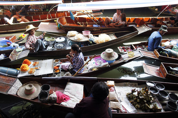 Floating markets in Thailand feature the old style and traditional way of selling goods from small boats on canals between traditional Thai houses and are also popular tourist attractions.