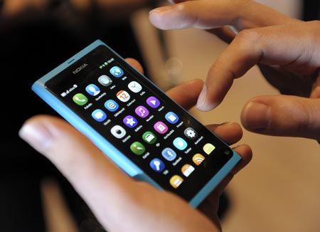 A staff member displays a Nokia N9 smartphone at a news conference in Espoo, June 21, 2011.