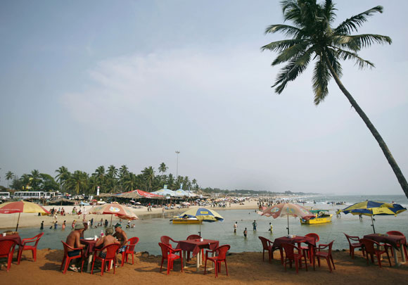 Tourists relax at a cafe on Baga beach in Goa