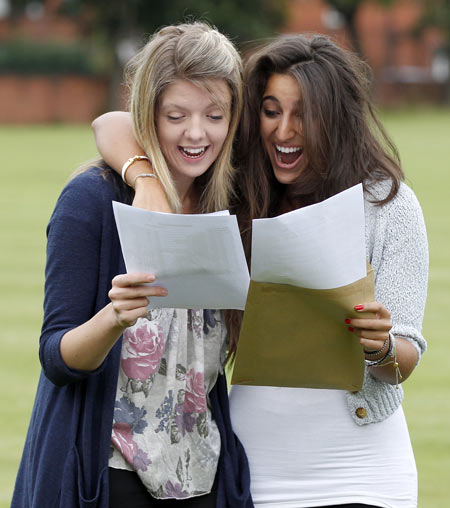 Students Alison Coxon (L, 5 A stars) and Claire Abrahams (3 A stars and one A) react as they open envelopes containing their A level examination results  at Withington Girls School in Manchester, northern England August 18, 2011.