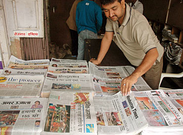 A vendor arranges Indian newspapers that carry reports and pictures of the Mumbai blasts in the northern Indian city of Allahabad July 12, 2006
