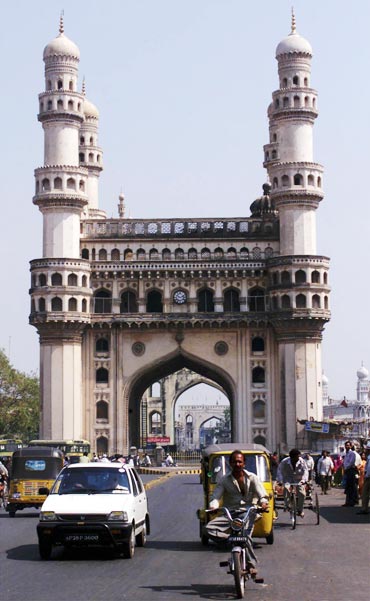 Residents of Hyderabad drive past the Charminar, the city's best known monument