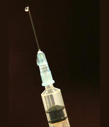 A syringe filled with water at the start of a mock mass vaccination in Bolton, northern England.