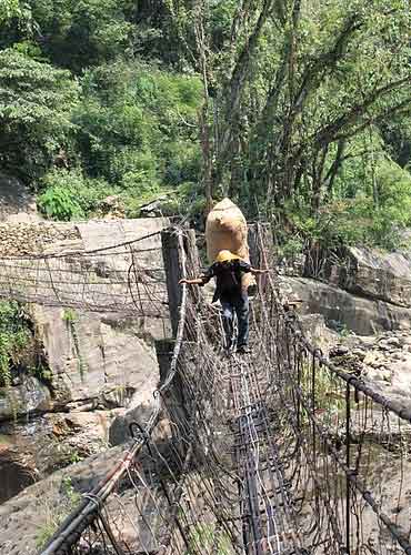 The narrow iron suspension footbridge.