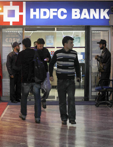 People walk in and out of a HDFC bank branch in Srinagar