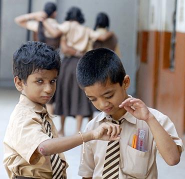 Visually impaired schoolboys play with a sacred thread known as Rakhi tied onto the wrist of one of the boys inside their school in the southern Indian city of Hyderabad