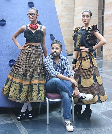 Sabyasachi Mukherjee with two of his creations poses for the shutterbugs. Sabya is scheduled to show on Friday, March 11