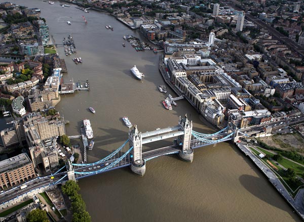An aerial view of the Thames river in London from the air with Tower Bridge in the foreground in London, England