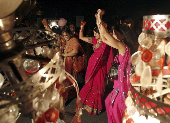 Indian women dance on the streets during a wedding in New Delhi