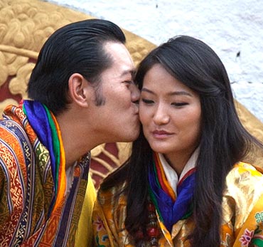 King Jigme Khesar Namgyel Wangchuck (L) kisses Queen Jetsun Pema in front of thousands of residents gathered for the third day of their wedding ceremony at the Changlimithang stadium in Bhutan's capital Thimphu on October 15, 2011