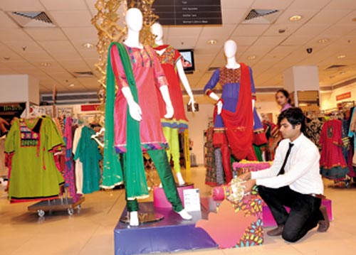 A visual merchandiser adds the finishing touches to a display at Shoppers Stop at MGF - Metropolitan Mall, New Delhi