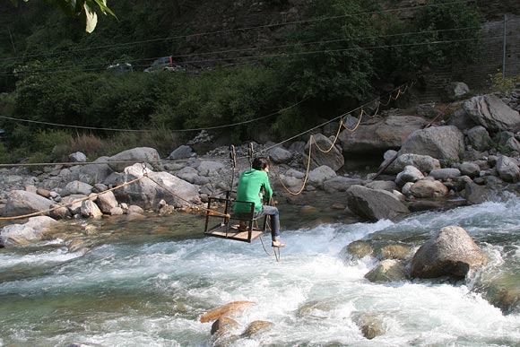 You have to cross the Tirthan river in a makeshift cable car to reach Raju's homestay.