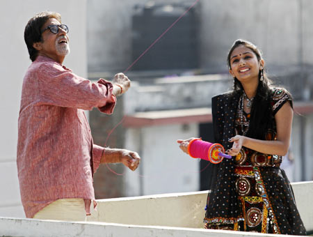 Bollywood actor Amitabh Bachchan (L) flies a kite during a shoot for a movie Khushboo Gujarat ki (or Fragrance of Gujarat) to promote tourism in India's western state of Gujarat, at Raipur in Ahmedabad.