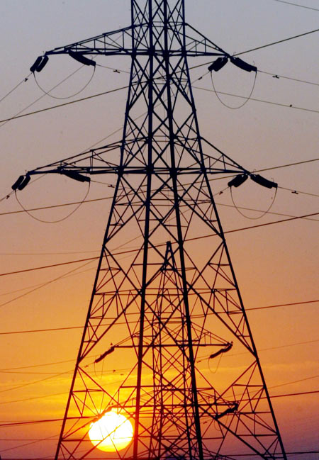 The sun rises behind electric pylons in the western Indian city of Ahmedabad, February 21, 2006. Power shortages and blackouts continue to plague India's major cities and undermine the confidence of investors and foreign companies operating in India.