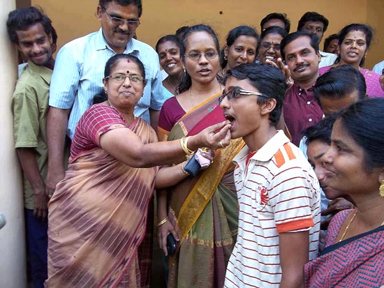 Venkatanathan Srinath (in striped tshirt) being offered sweets at school