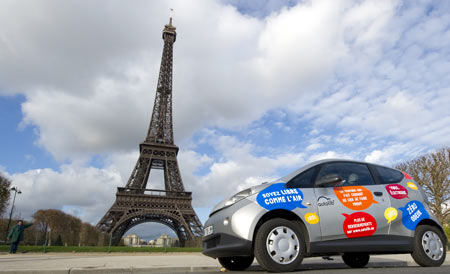 A Paris Autolib' electric car is parked near the Eiffel tower during a presentation ride in Paris