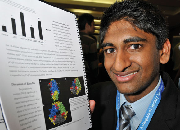 Nikhil shows off his project on cancer research that won him the prize