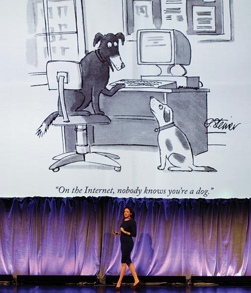 Sheryl Sandberg delivers a speech beneath a New Yorker magazine cartoon