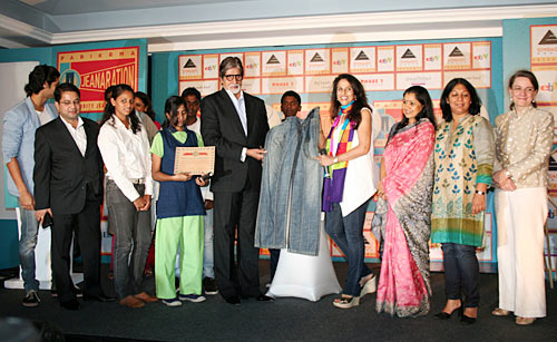 Amitabh Bachchan and Shobhaa De display the jeans they are auctioning for Parikrama at the event, flanked by students and administrators of the school