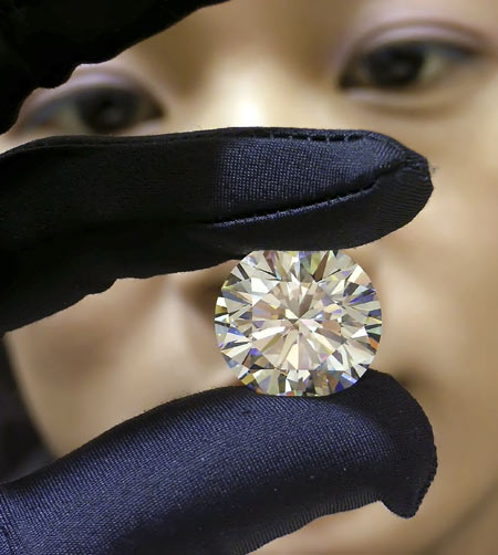 A saleswoman displays a 26.62 carat diamond at a shopping centre in Nanning, south China's Guangxi province. The diamond is valued at 41,200,000 yuan ($5,253,000) and belongs to a Belgian company.