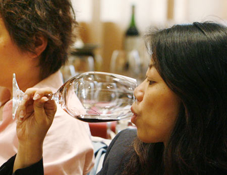 Wine lovers try red wine during a Chateau Haut Brion wine-tasting event in Beijing