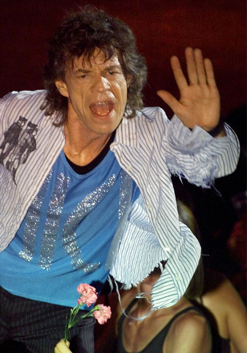 Rolling Stones lead singer Mick Jagger waves towards fans as he performs at the start of the first theater concert of the Rolling Stones' 2002 Licks World tour September 8, 2002 at the Orpheum Theater in Boston. The tour contains a mix of arenas, stadiums and smaller theater venues.