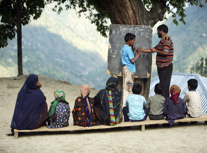 A teacher teaches counting techniques to a deaf and mute boy at an open air class at Dadhkai Village in the Doda district, 260 km (162 miles) north of Jammu, June 18, 2009. Silence reigns in this sleepy village nestled high up in the Himalayan mountains in northern India and where the majority of residents are either deaf or mute. Each of the 47 families in this village in Jammu and Kashmir state have a least one member who can neither hear nor speak. The first reported case dates back to 1931 and now the numbers have swelled to 82.