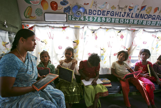 Teacher H. Laxmi conducts lessons inside a bus which has been converted into a school called School on Wheels at a slum area in the southern Indian city of Hyderabad November 1, 2011. The mobile school, run by CLAP Foundation, a non-governmental organisation, brings education to the doorstep of disadvantaged children every day, halting for several hours at a time in different parts of the sprawling city. The children, whose parents are day labourers on construction sites, or work as rag pickers and maids, either never go to school or drop out once enrolled. Many have to work as hard as their parents to pay off family debts.