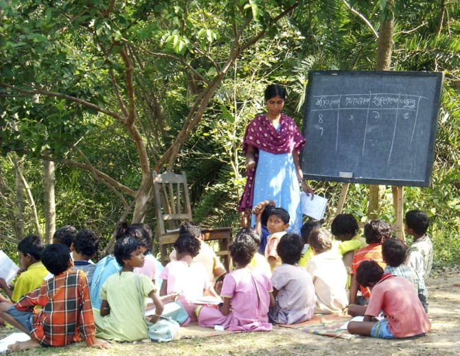 Children sit on the ground in a outdoor school during a lesson in Santiniketan village in this undated handout photograph. In Santiniketan village in West Bengal -- the home of Nobel literature prize winner Rabindranath Tagore -- a voluntary initiative helping local Kora and Santhali tribal children to read and write Bengali is now so popular it needs a second building.