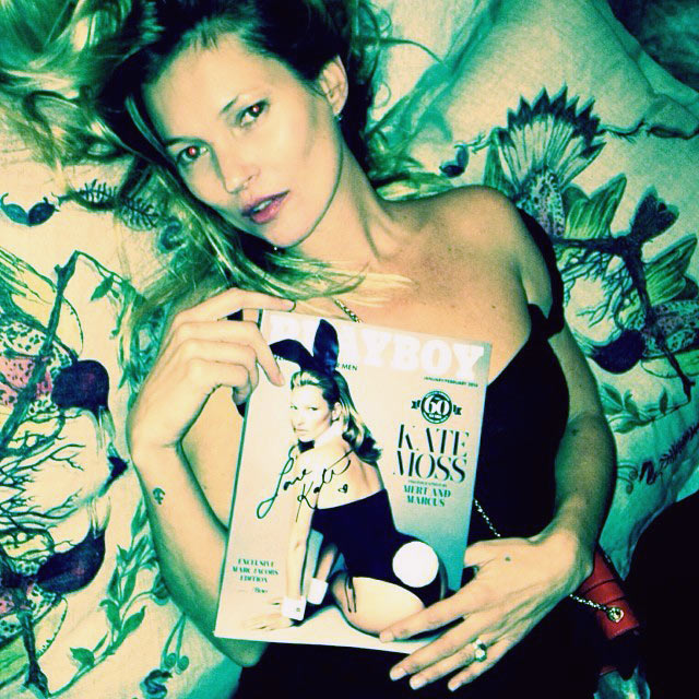 Kate Moss poses with a picture of the latest Playboy issue featuring her on the cover.