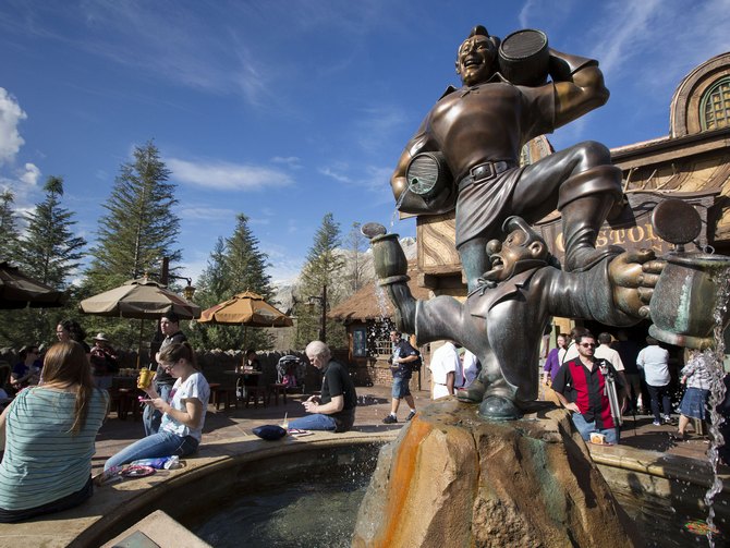 Guests gather around a fountain near Gaston's Tavern following the grand opening ceremony for Walt Disney World's new Fantasyland in Lake Buena Vista, Florida 