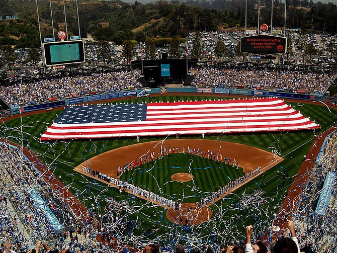 Sailors and Marines unfurl a football field-sized American flag at Dodger Stadium during the pre-game activities before a Major League Baseball game between the Los Angeles Dodgers and the San Francisco Giants.