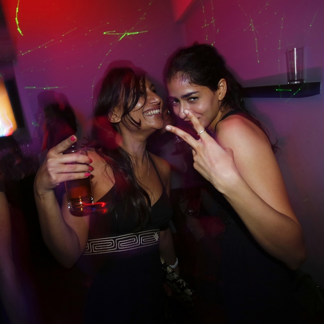 Malini Agarwal (L), blogger-in-chief of missmalini.com, smiles as she dances with a friend at a newly-opened nightclub in Mumbai,