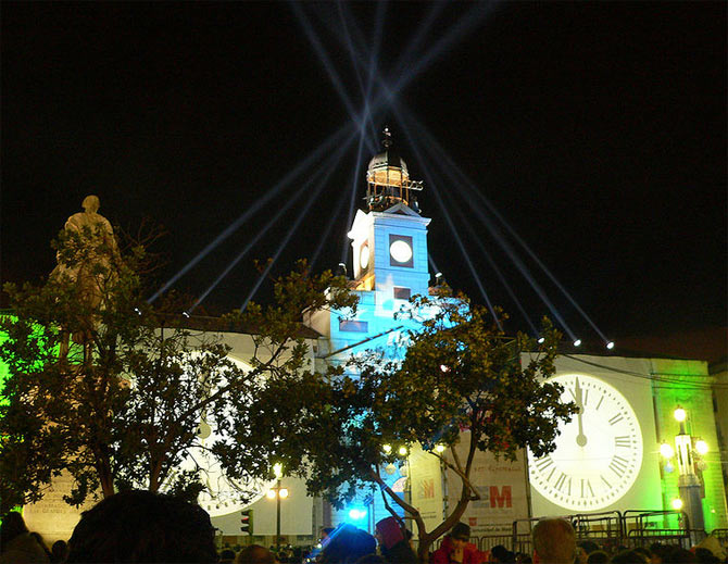 The clock on top of the Casa de Correos building is lit up for New Year