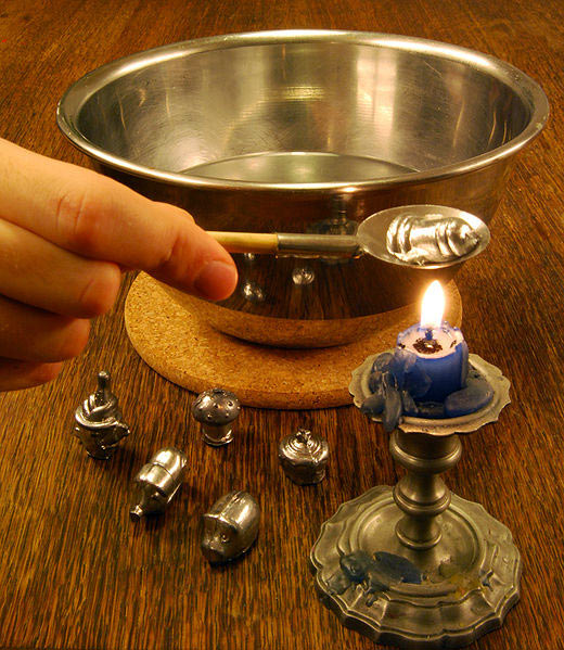 A woman lights a small quantity of lead over a candle on New Year's eve