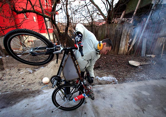 Raul Oaida prepares his bicycle propelled with a self-built jet engine to be tested on a road in the back of his house in Deva, 399 km (245 miles) of Bucharest.