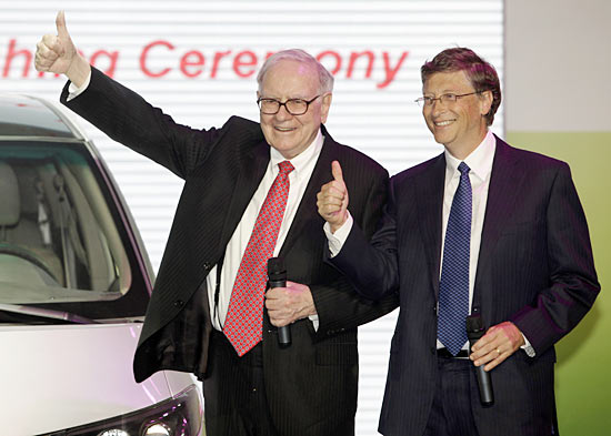 Billionaire financier and Berkshire Hathaway Chief Executive Warren Buffett (L) and Microsoft founder Bill Gates gesture at the national launch ceremony for the BYD M6 vehicle in Beijing