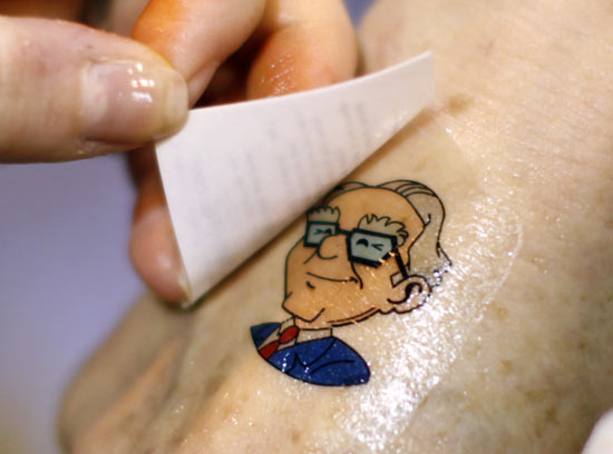 A Berkshire Hathaway shareholder has a temporary tattoo of BH Chairman Warren Buffett applied to her hand at the company trade show during the BH annual meeting in Omaha, Nebraska