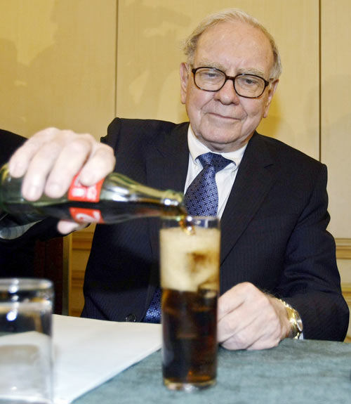 US Investor Warren Buffett fills a glass with Coke during a news conference in Madrid